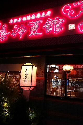 「喜神菜館」の店名のネオンサイン